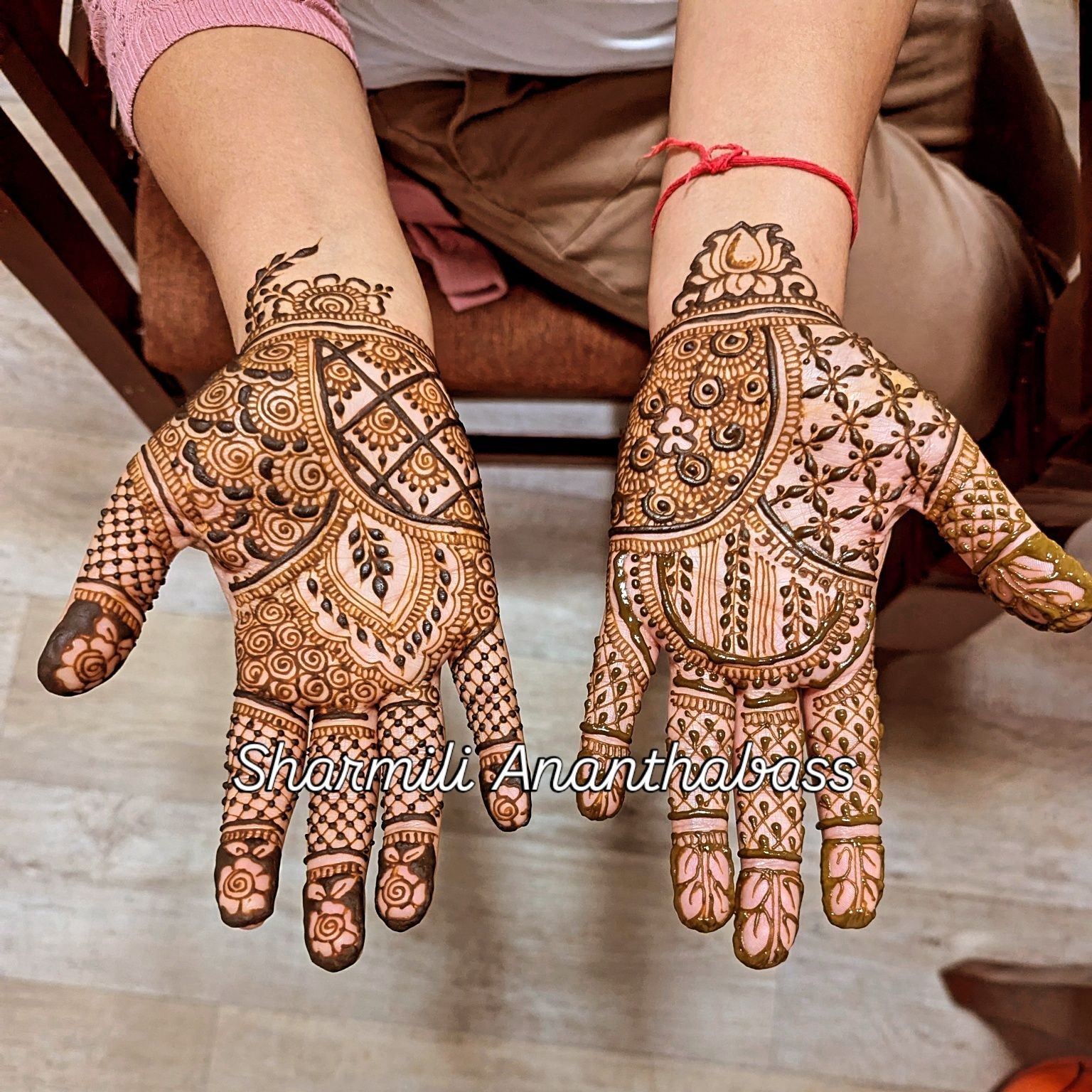 Intricate henna designs on both palms with detailed patterns and floral motifs.