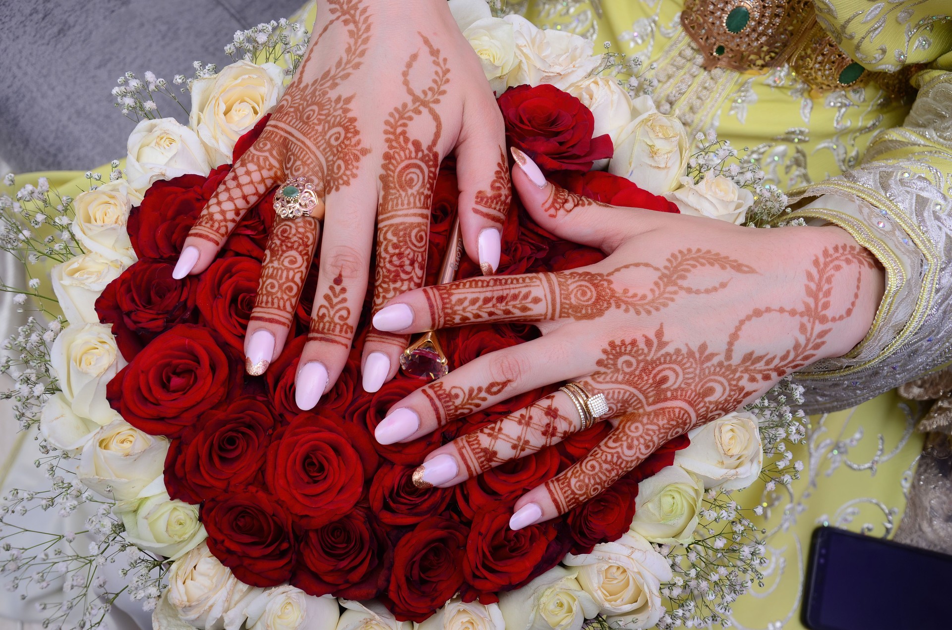 Henna Tattoo on Bride's Hand.Moroccan wedding preparation henna party. Temperate white mehndi. Modern mehendi art.