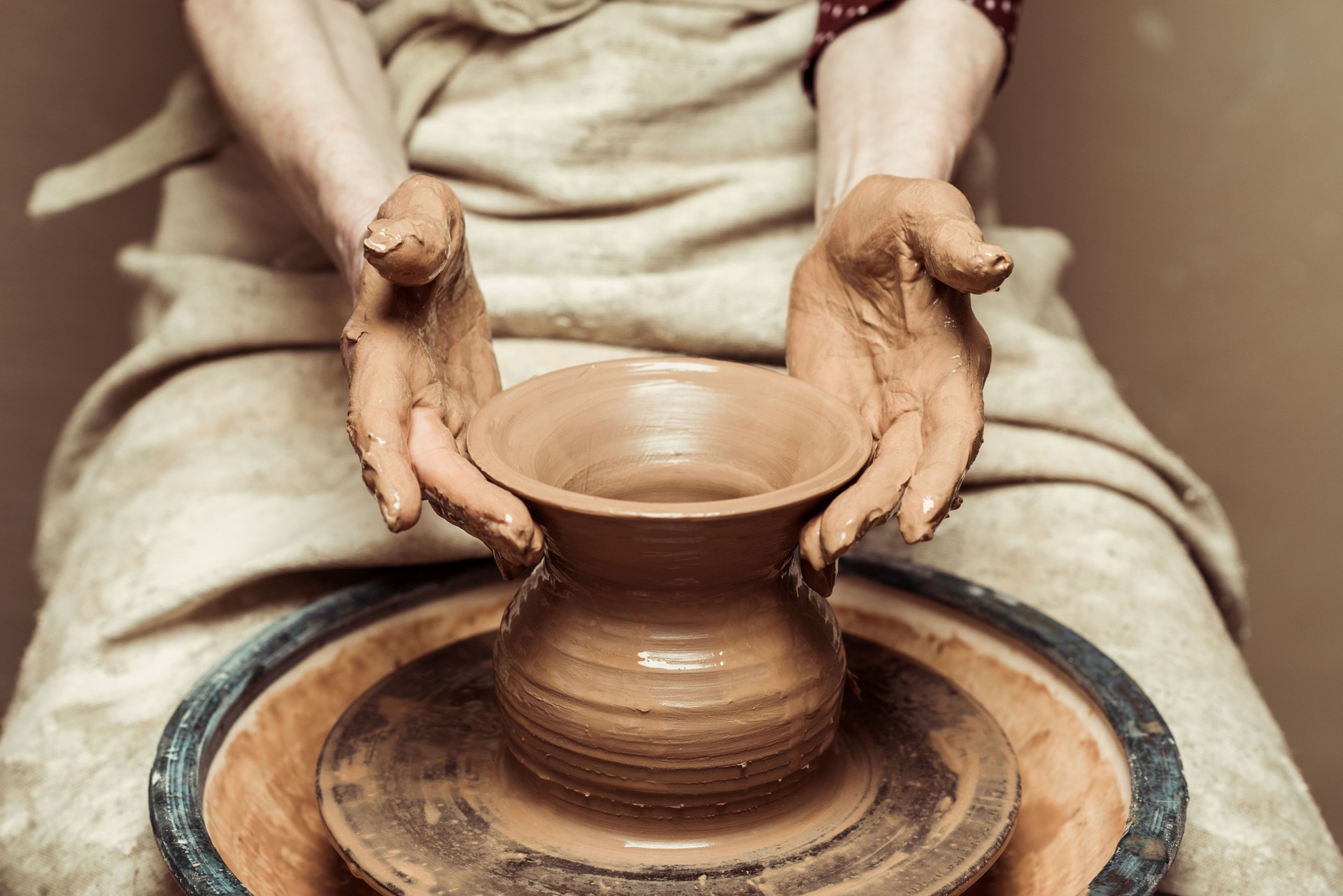 Close up of female hands working on potters wheel